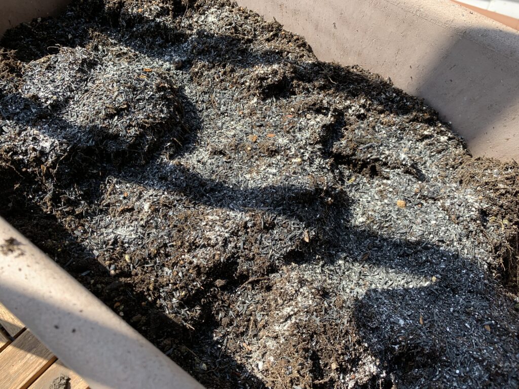 くん炭と化成肥料を入れてよく混ぜる様子